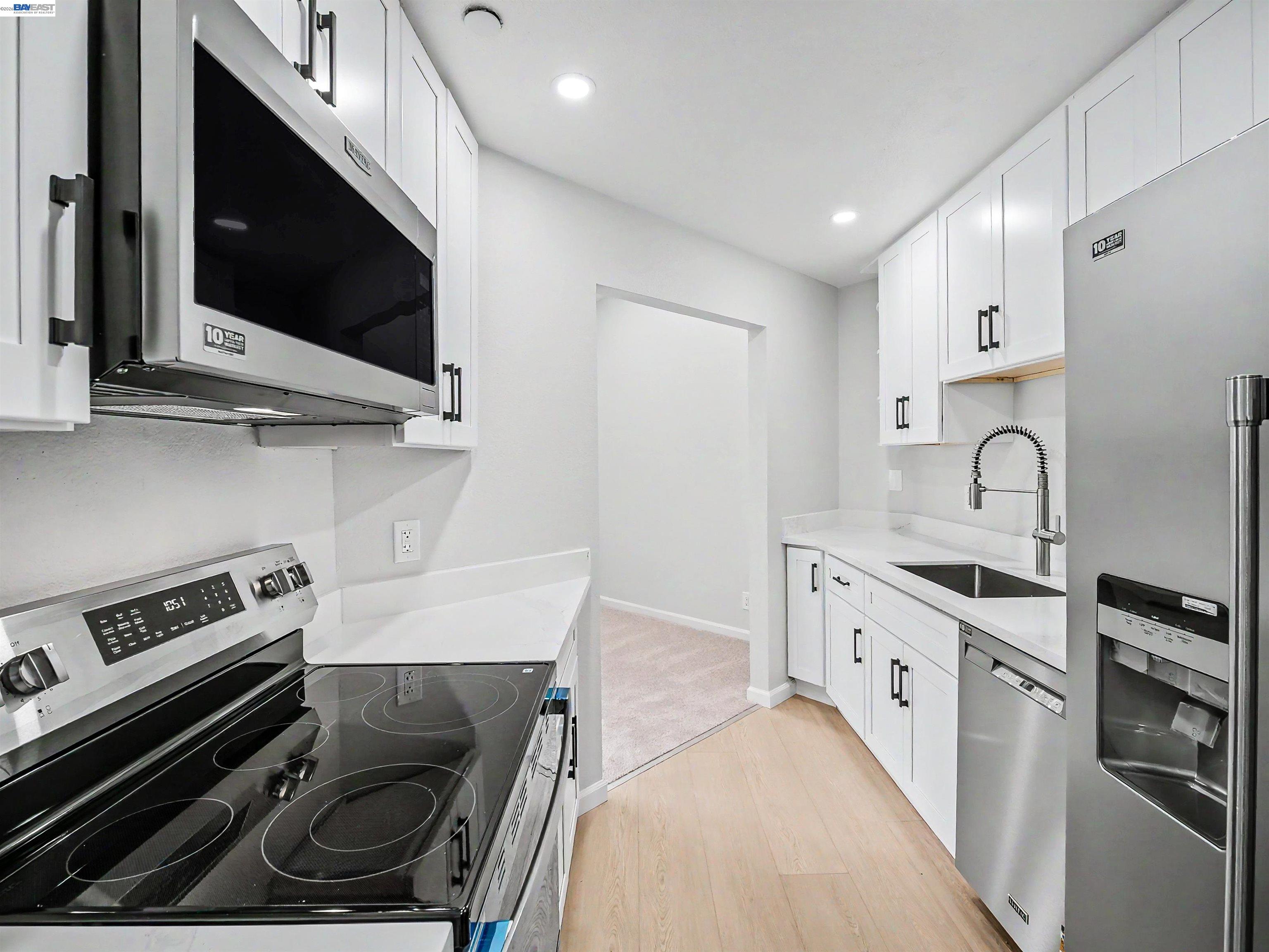 39450 Albany Common, Unit X Fremont, CA 94538 - Photo 24 of 46 a kitchen with stainless steel appliances a stove a microwave a sink and cabinets