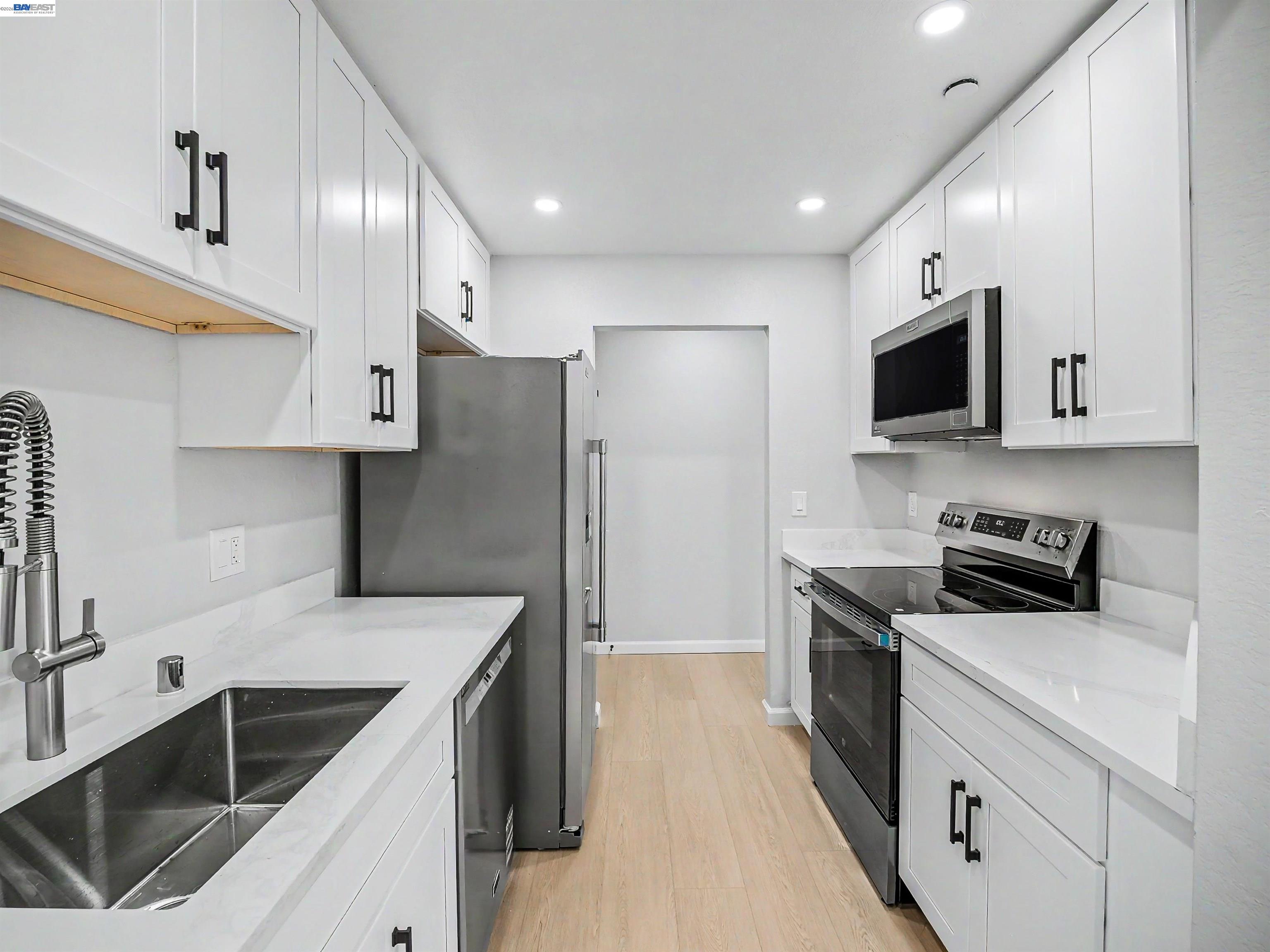 39450 Albany Common, Unit X Fremont, CA 94538 - Photo 25 of 46 a kitchen with stainless steel appliances a stove sink microwave and cabinets