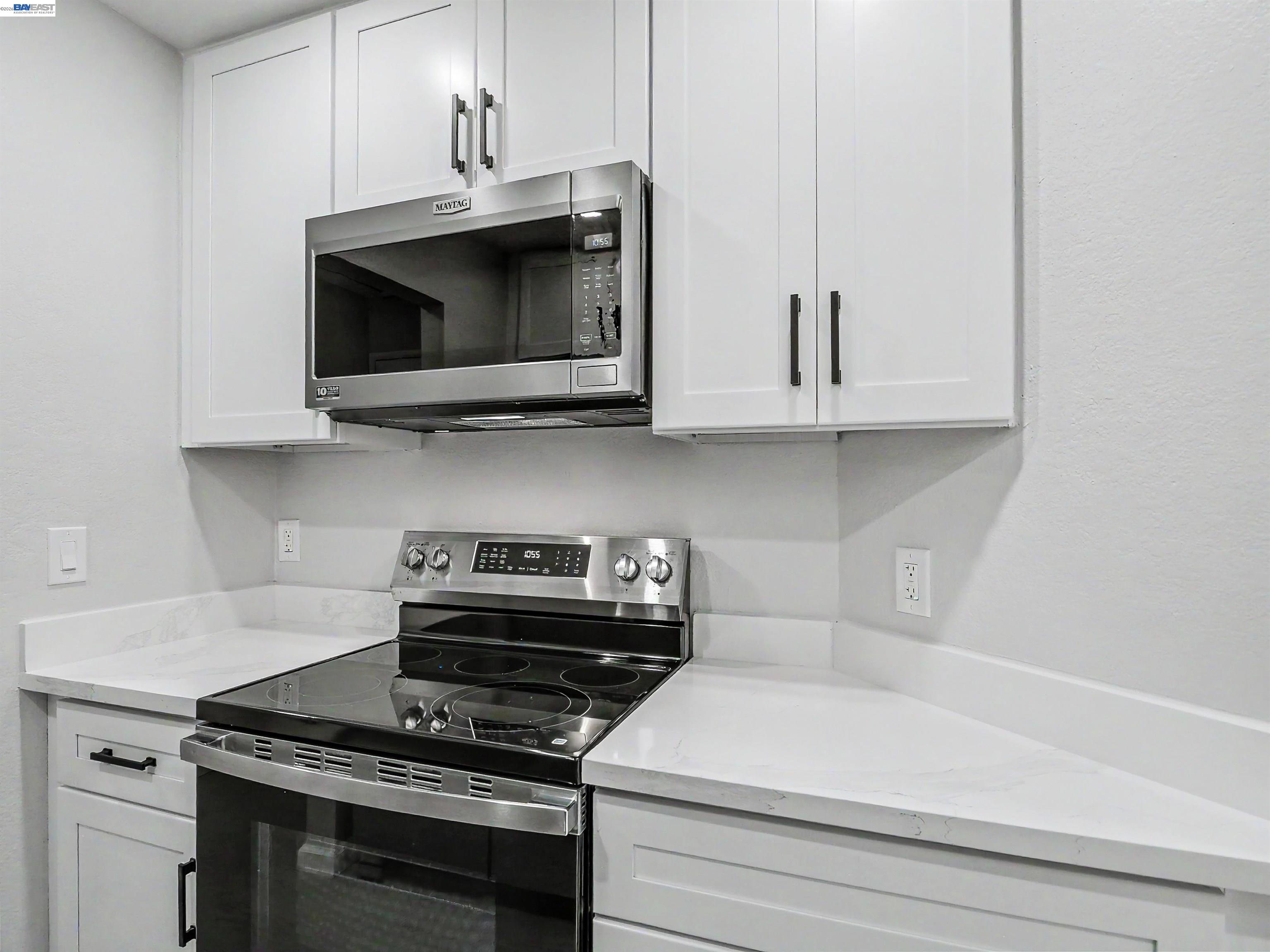 39450 Albany Common, Unit X Fremont, CA 94538 - Photo 8 of 46 a kitchen with stainless steel appliances a stove a microwave and cabinets