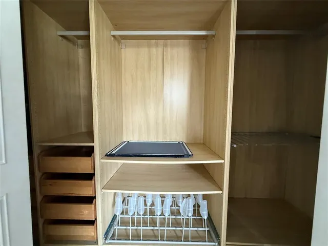 a view of walk in closet with empty racks