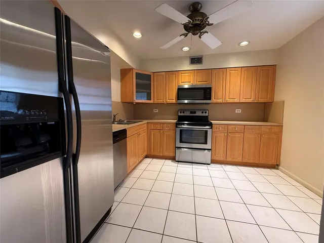 a kitchen with stainless steel appliances granite countertop a refrigerator and a sink