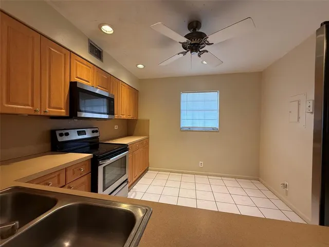 a kitchen with a sink a stove and a microwave oven