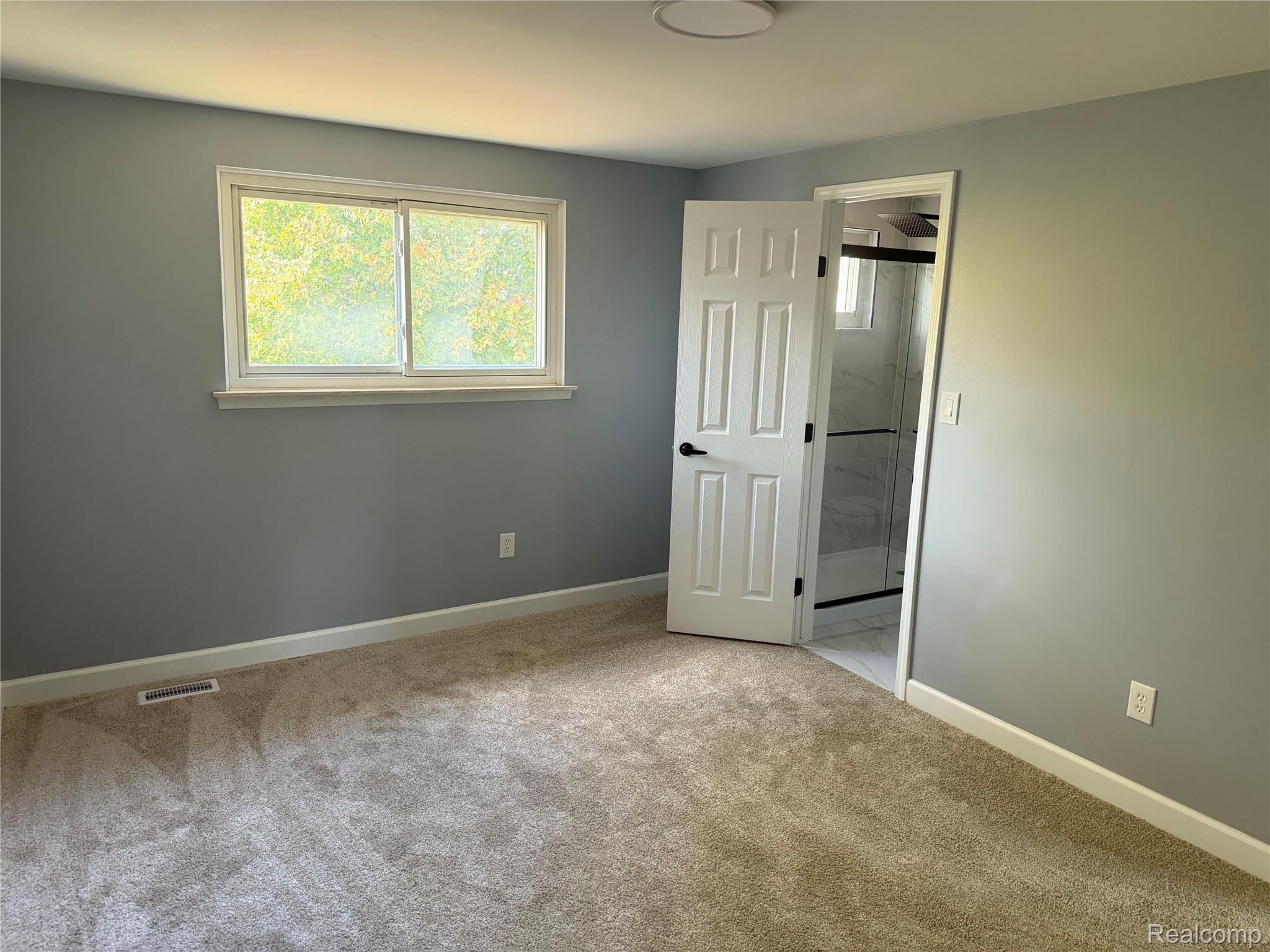20698 Coachwood Road Riverview, MI 48193 - Photo 30 of 37 Unfurnished bedroom featuring multiple windows, light carpet, and connected bathroom