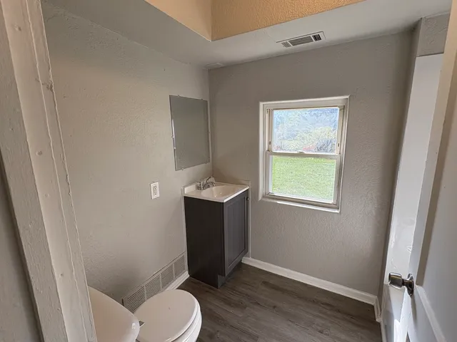 a bathroom with sink toilet and window