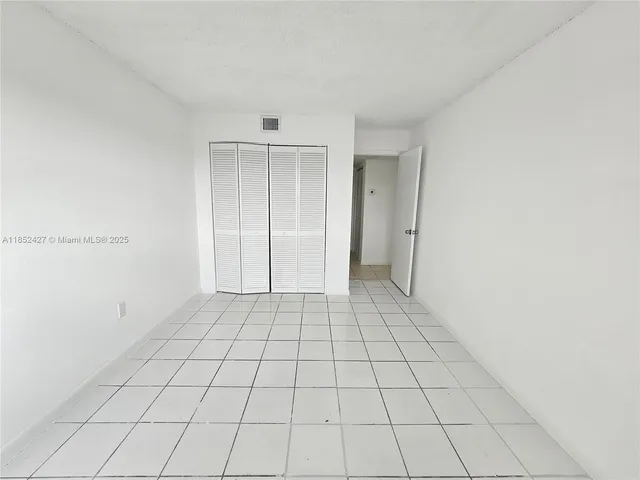 an empty room with white walls and tiles
