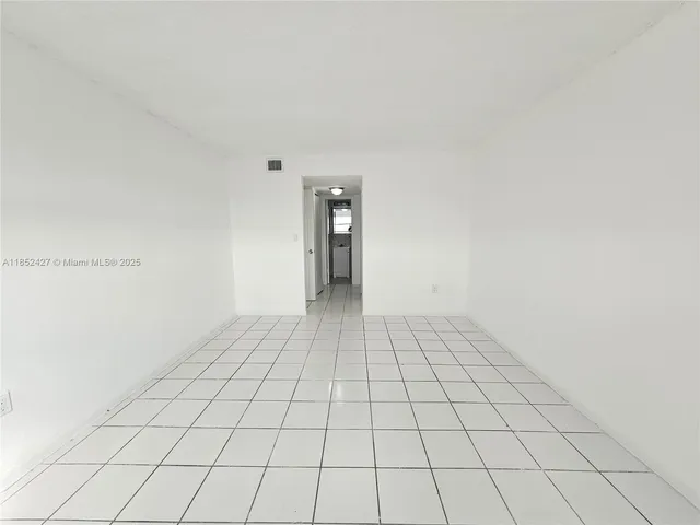 an empty room with white walls and tiles