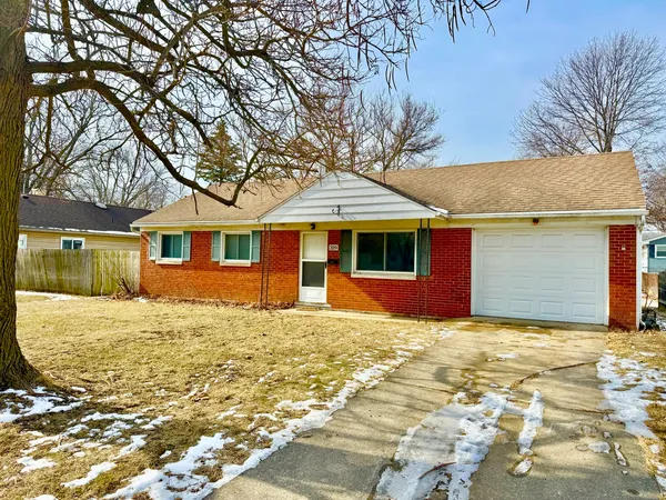 a view of a yard in front of a house with a large tree