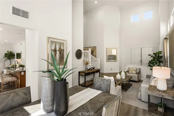 a kitchen with stainless steel appliances granite countertop a stove a refrigerator a microwave a dining table and chairs with wooden floor
