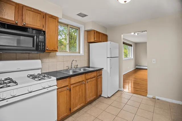 a kitchen with stainless steel appliances granite countertop a refrigerator sink and stove
