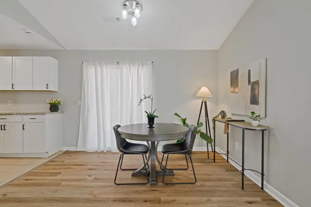 a dining room with furniture and a potted plant