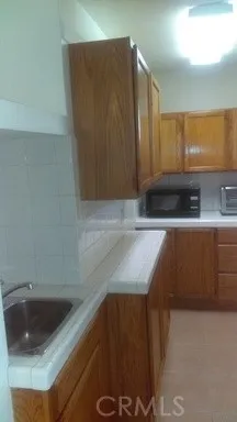 a kitchen with granite countertop a sink a stove and cabinets