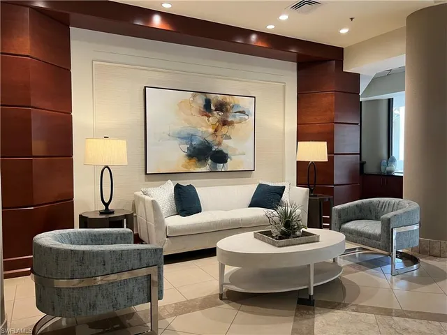 a living room with furniture and a painting on the wall