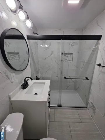 a bathroom with a sink a toilet and a mirror