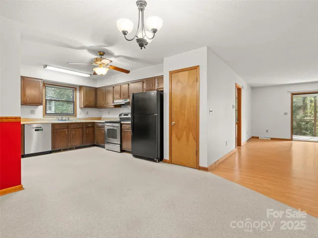 a large kitchen with stainless steel appliances granite countertop a refrigerator and a sink