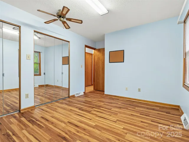 a view of a room with wooden floor and ceiling fan