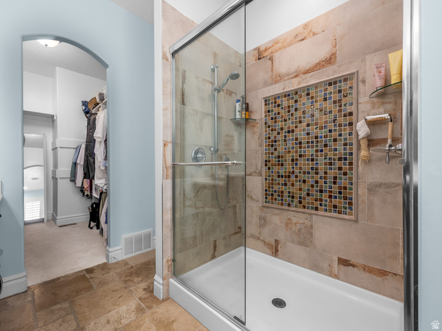 968 South Cyn Road Santaquin, UT 84655 - Photo 13 of 36 Shower enclosure with glass doors and a mosaic tile accent niche, complemented by natural stone-finish wall tiling