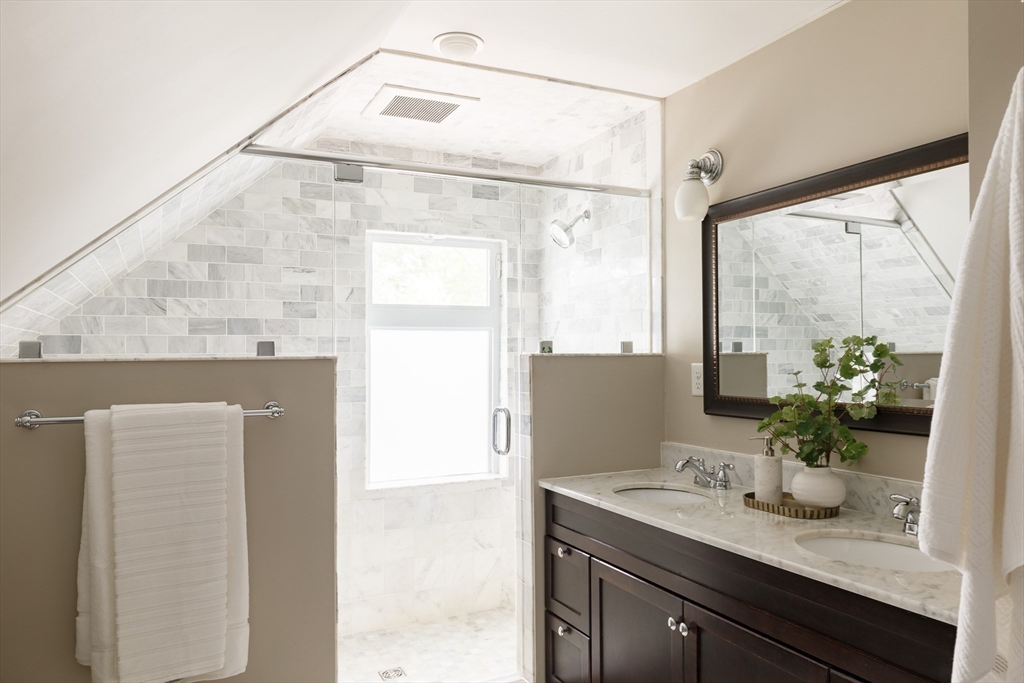 128 Thorndike Street, Unit 128 Arlington, MA 02474 - Photo 13 of 20 a bathroom with a granite countertop sink and a mirror
