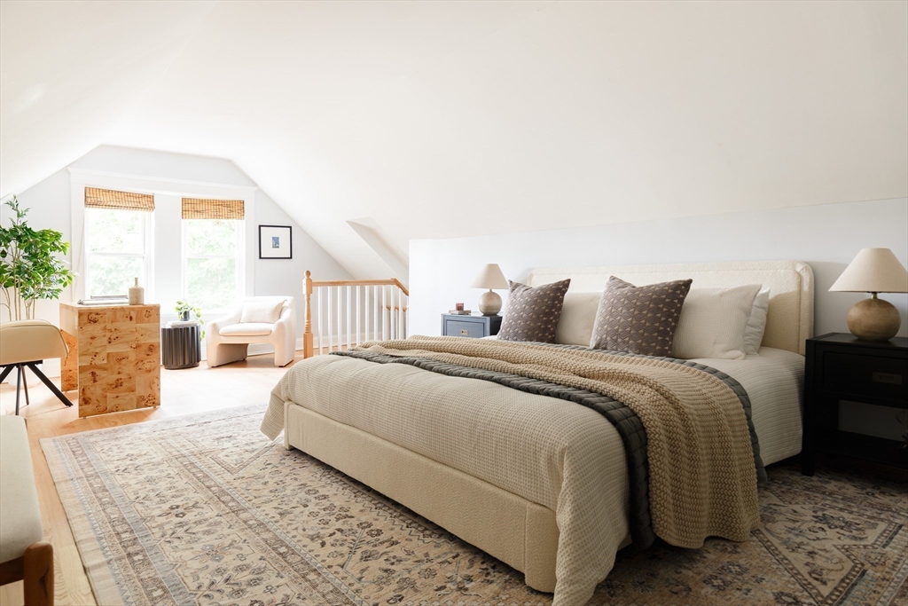 128 Thorndike Street, Unit 128 Arlington, MA 02474 - Photo 10 of 20 a spacious bedroom with a bed and chair