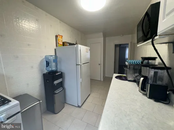 a kitchen with white cabinets sink and stove