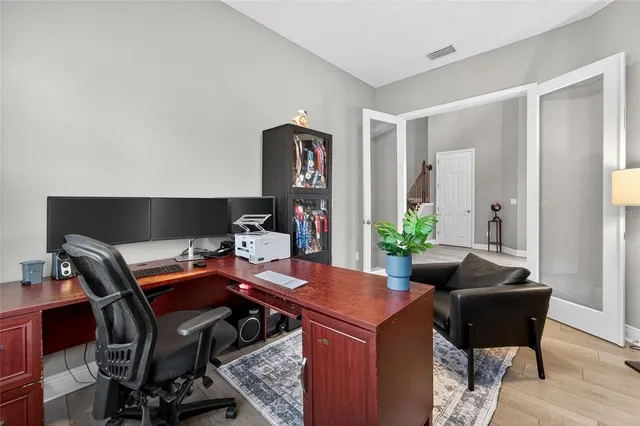a large kitchen with cabinets chairs and stainless steel appliances
