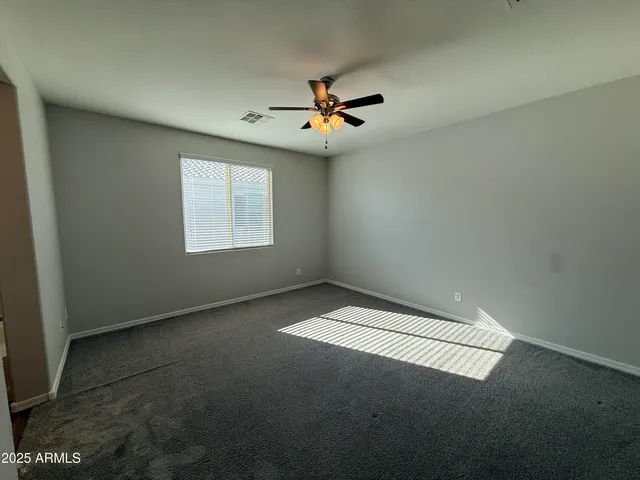 a view of an empty room with a ceiling fan
