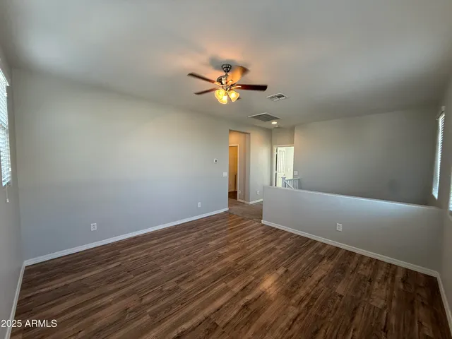 an empty room with windows and fan
