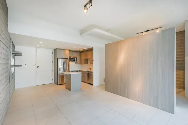 a view of a kitchen with refrigerator and white cabinets