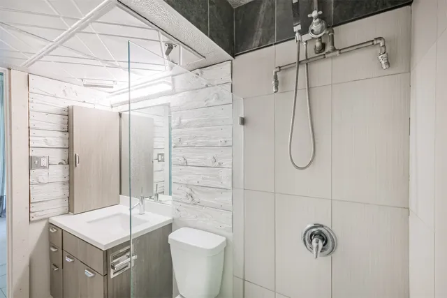 a bathroom with a shower a toilet and sink