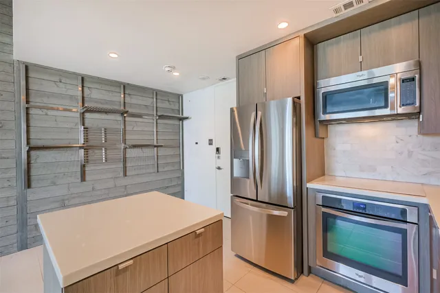 a kitchen with stainless steel appliances a refrigerator and a stove top oven