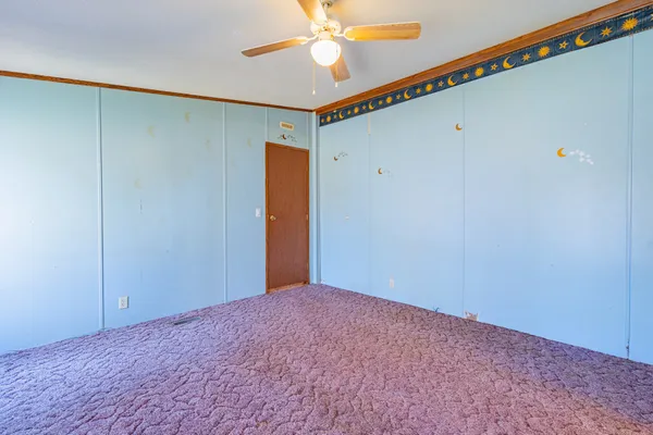 a view of empty room with window and ceiling fan
