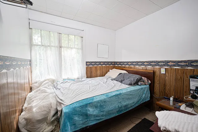 a bedroom with a bed and wooden floor