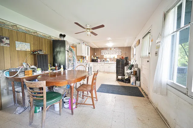 a dining area with stainless steel appliances a table chairs and a refrigerator