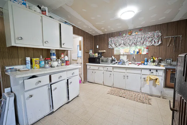 a kitchen with white cabinets sink and white appliances