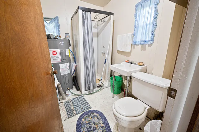 a white toilet sitting next to a bathroom sink and a mirror