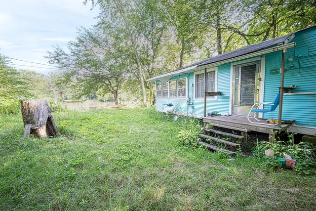 a backyard of a house with table and chairs