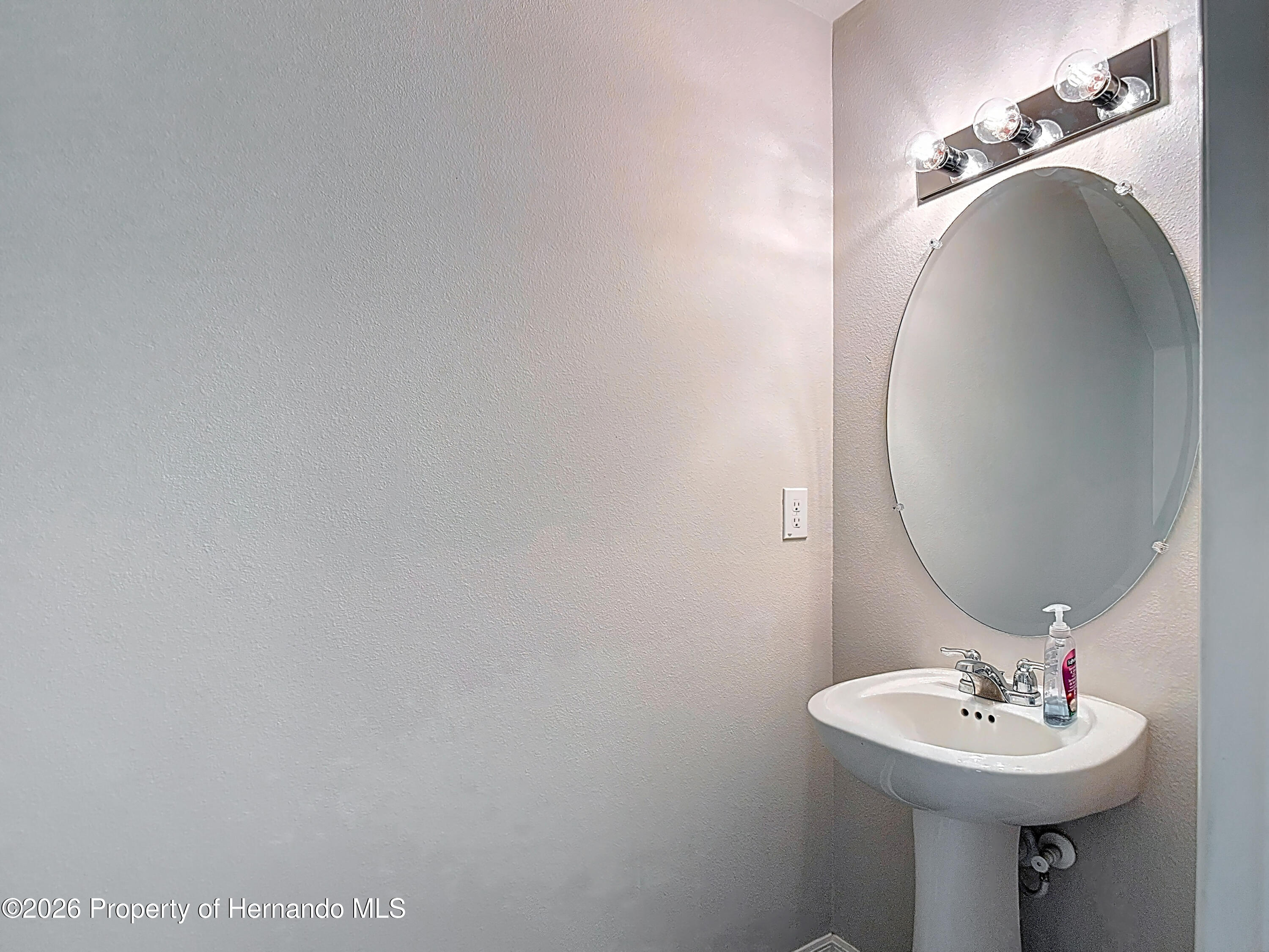 11374 Marcella Avenue Weeki Wachee, FL 34614 - Photo 29 of 70 a bathroom with a sink and mirror