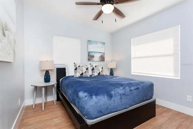 a bed sitting in a bedroom next to a window with chandelier