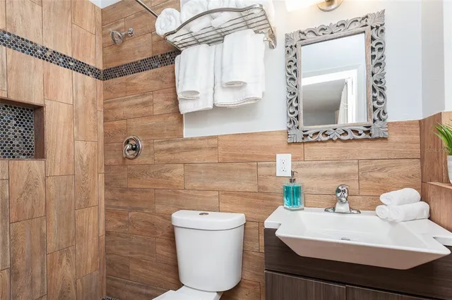 a bathroom with a sink a toilet and mirror