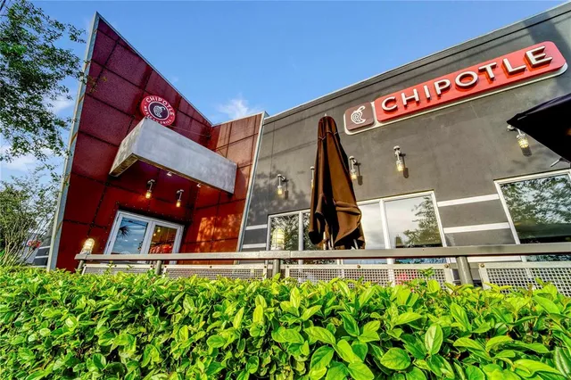 a front view of a house with a yard and potted plants