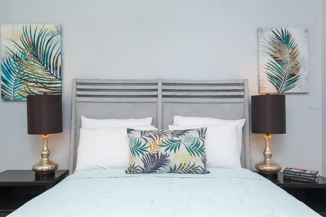 a bedroom with a bed and a potted plant