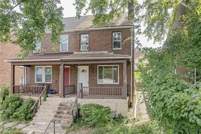a view of a house with a yard and potted plants