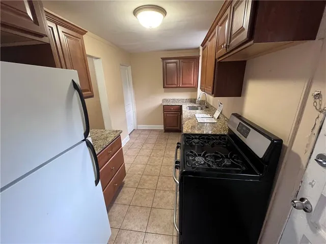 a kitchen with granite countertop a stove and a refrigerator