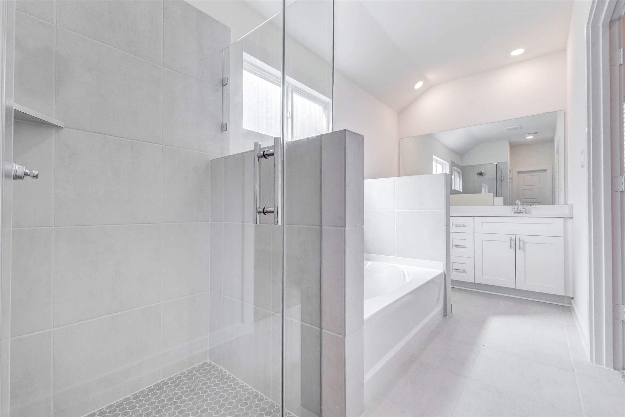 6467 Escondido Drive Rosharon, TX 77583 - Photo 20 of 32 Primary bath view highlighting the glass-enclosed walk-in shower, soaking tub, dual-sink vanity, neutral tile flooring, and bright natural light. The separation between the tub and shower adds comfort and function, while the clean finishes give the space a fresh, spa-inspired look.