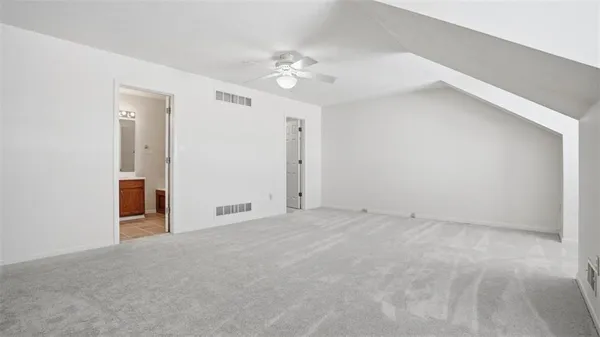 a view of an empty room with a chandelier fan