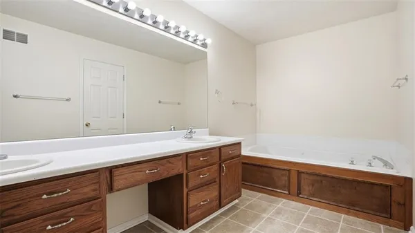 a spacious bathroom with a granite countertop sink and a mirror