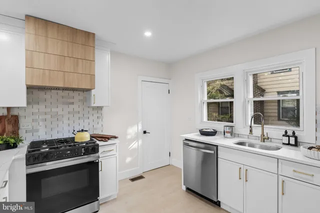 a kitchen with white cabinets and appliances