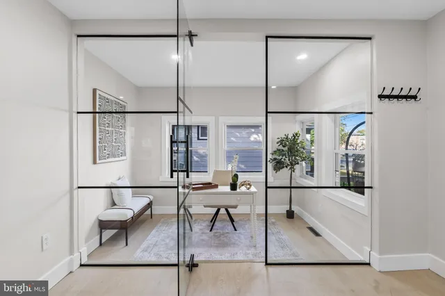 a living room with a glass table and a painting on the wall