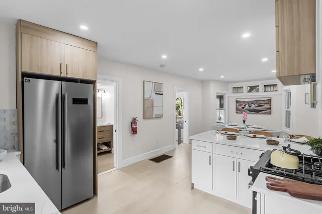 a room with stainless steel appliances kitchen island a refrigerator sink and stove