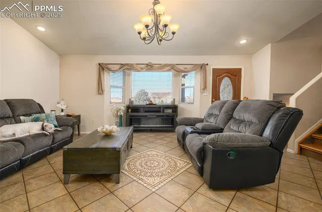 a living room with furniture and a chandelier