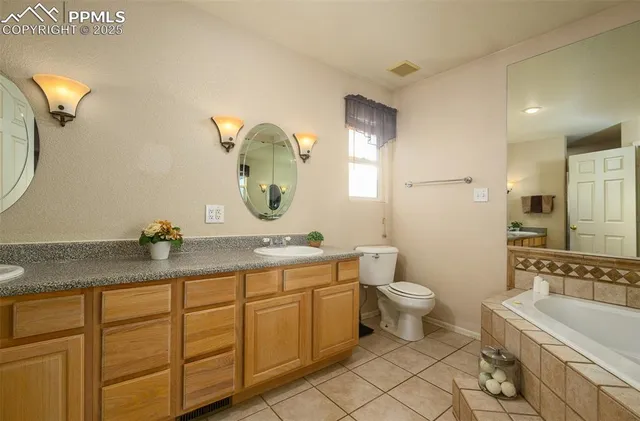 a bathroom with a granite countertop sink mirror and toilet